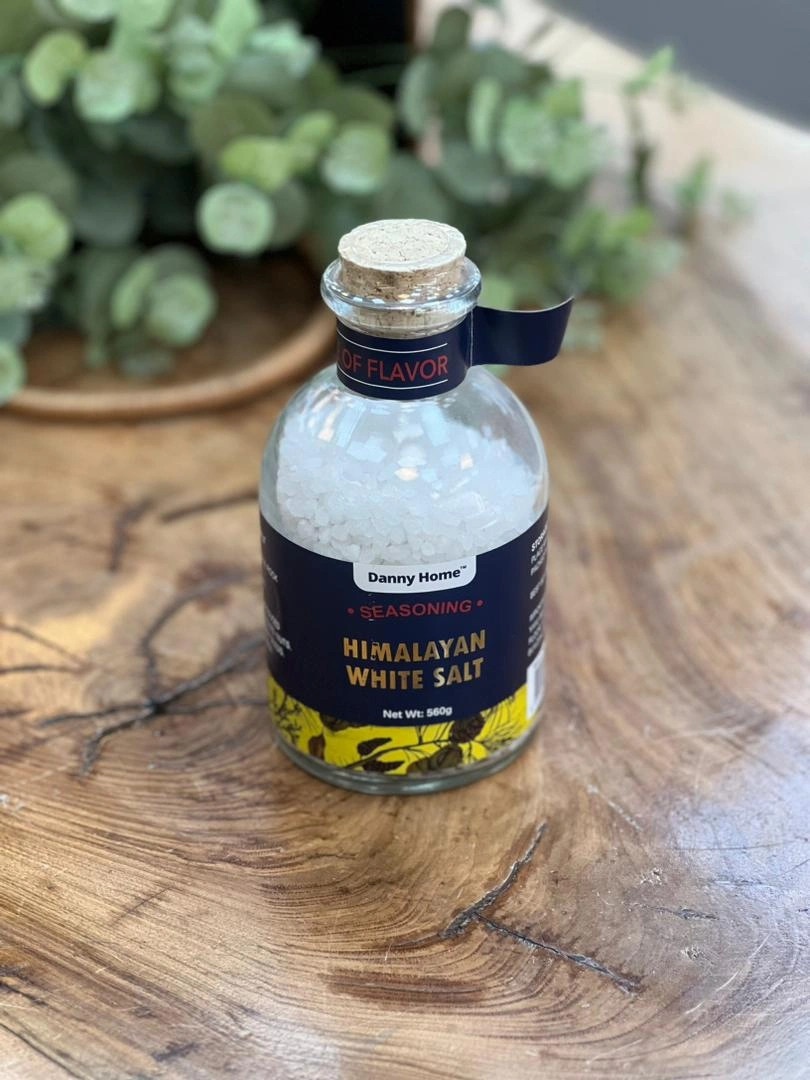 ۷. توضیح کوتاه برای عکس: نمک سفید دنی هوم در بسته‌بندی شیشه‌ای ۵۶۰ گرمی