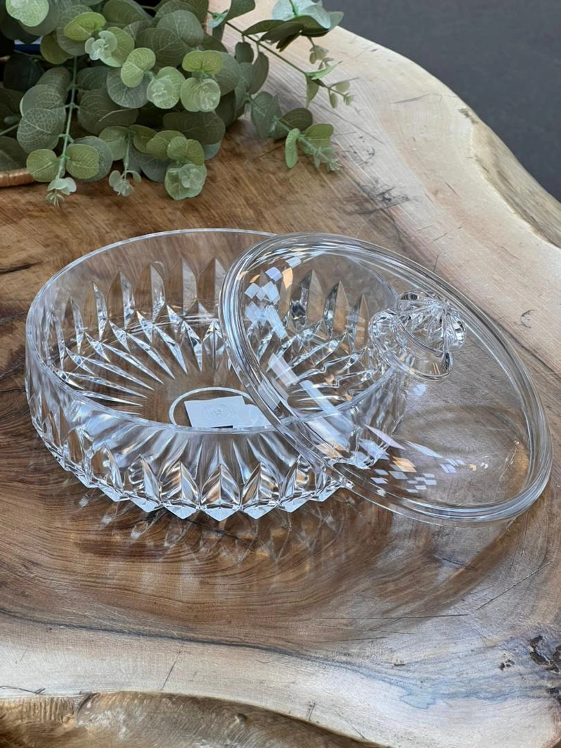 بیسکوییت‌خوری گرد اکرولیک شفاف با درب طراحی‌شده، قرار گرفته روی میز چوبی