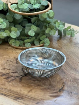 تصویر سبد پسماند استیل مشبک با دسته فلزی، مناسب قرارگیری داخل سینک آشپزخانه.