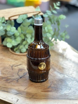 تصویر بطری شیشه‌ای دنیز مدل باروک با رنگ قهوه‌ای تیره و طراحی بشکه‌ای کلاسیک همراه با درب فلزی براق.