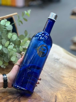 بطری شیشه‌ای آبی کوره‌ای دنیز مدل دارلین با درب فلزی پیچی و طراحی خاص یک لیتری