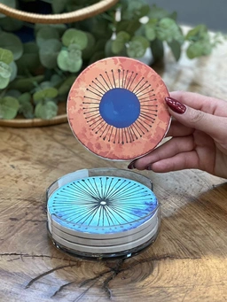 تصویر ست چهار عددی زیر لیوانی دنی هوم با طرح‌های رنگی متنوع و استند شفاف نگه‌دارنده.