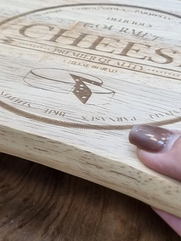 تخته سرو پنیر چوبی با طراحی حک‌شده و سه ابزار فلزی که به‌صورت مگنتی زیر تخته نگهداری می‌شوند.